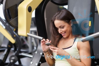 Woman Using Mobile Phone On A Break In Health Club Stock Photo
