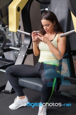 Woman Using Mobile Phone On A Break In Health Club Stock Photo