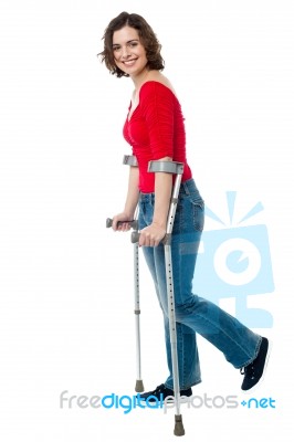Woman Walking With The Help Of Crutches Stock Photo