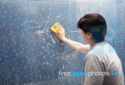 Woman Washes The Tile On The Wall With A Cloth Lather Stock Photo