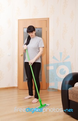 Woman Washes Wooden Floor With A Mop Stock Photo