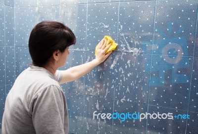 Woman Washing Tile On The Wall With A Cloth Lather Stock Photo