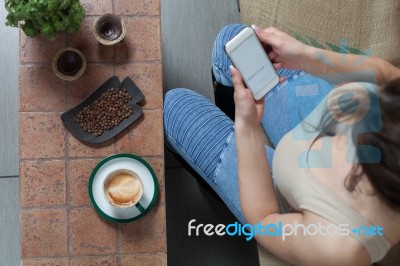 Woman With Coffee Cup On Ceramic Table And Mobile Phone Stock Photo