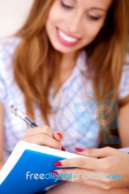 Woman Writing In Notepad Stock Photo