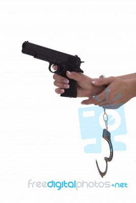 Woman's Hand With Handcuffs And Gun On A White Background Stock Photo