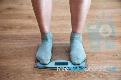 Woman's Legs Standing On The Scales Stock Photo