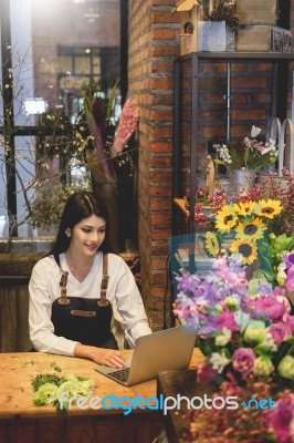 Women Florist Looking Laptop Got Order At Counter Of Her Flower Stock Photo