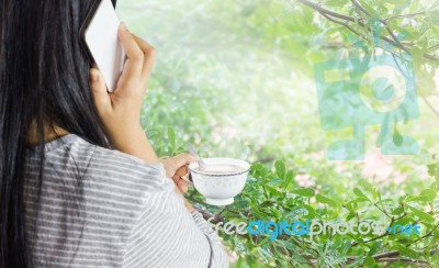 Women Hold Cup Of Coffee And Talking On Mobile Or Smartphone Stock Photo