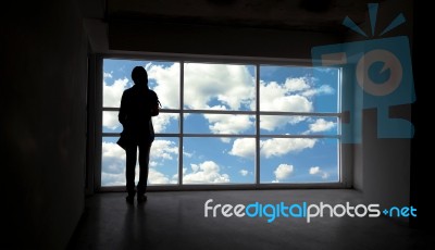 Women Silhouette Beside The Big Window And Sky Background Stock Photo