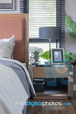 Wooden Bed With Black Lamp On Wooden Table Stock Photo