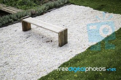 Wooden Bench In Rock Garden Stock Photo