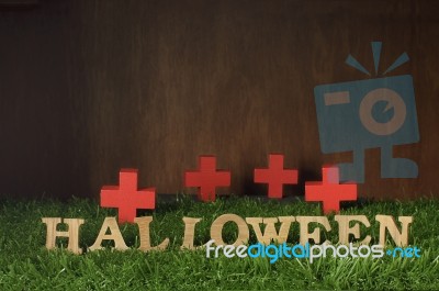 Wooden Halloween Words And Wooden Cross On Grass Background Stock Photo
