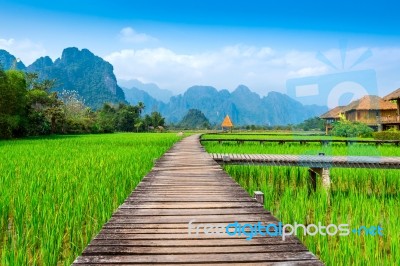 Wooden Path And Green Rice Field In Vang Vieng, Laos Stock Photo