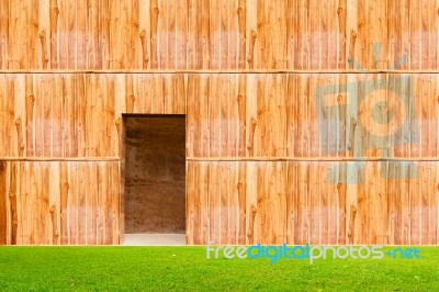 Wooden Wall With Door And Grass Floor In Front Off Stock Photo
