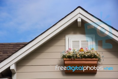 Wooden Window With Flower At The Roof Of The House Stock Photo