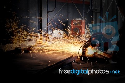 Worker Cutting Metal With Grinder. Sparks While Grinding Iron Stock Photo