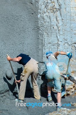 Worker Shovelling Concrete Stock Photo