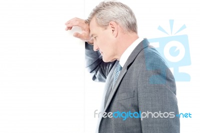 Worried Businessman Leaning Head On Wall Stock Photo