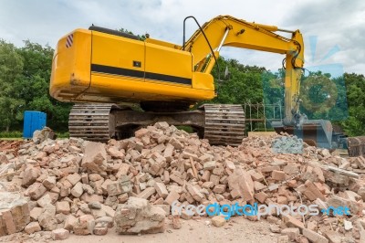 Yellow Belt Excavator On Heap Of Bricks Stock Photo