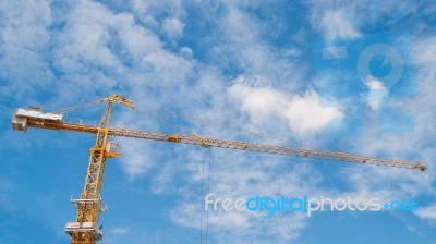 Yellow Construction Tower Crane With Blue Sky Stock Photo