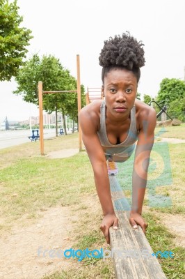 Young African Woman Doing Pushups Stock Photo