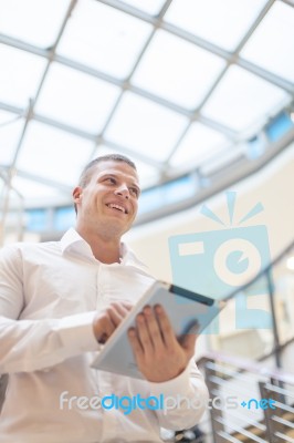 Young And Smiling Man With Tablet Computer In Modern Business Bu… Stock Photo