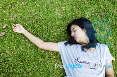 Young Beautiful Asian Laying On The Grass Stock Photo