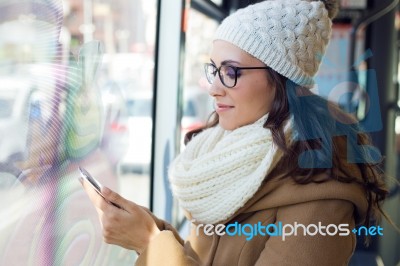 Young Beautiful Woman Using Her Mobile Phone On A  Bus Stock Photo