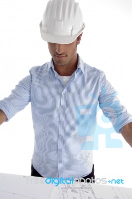 Young Caucasian Architect In Helmet Having A Look At Blueprints Stock Photo