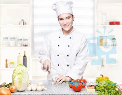Young Chef Cutting Onions In Kitchen Stock Photo