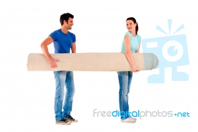 Young Couple Carrying A Carpet Stock Photo