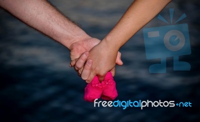 Young Couple Holding Baby Shoes Stock Photo