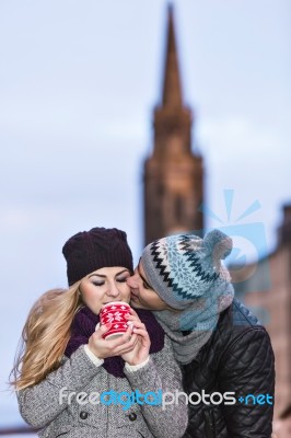 Young Couple In Love Embracing And Drinking Hot Drink From Red C… Stock Photo