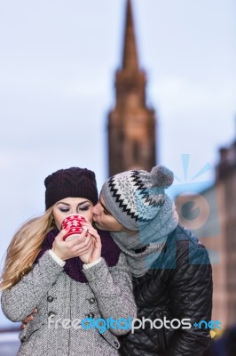 Young Couple In Love Embracing And Drinking Hot Drink From Red C… Stock Photo