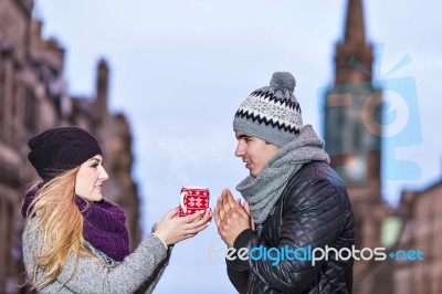 Young Couple In Love Sharing A Cup Of Hot Drink On A Cold Winter… Stock Photo