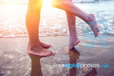 Young Couple Legs On The Beach Sand Stock Photo