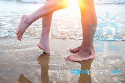 Young Couple Legs On The Beach Sand Stock Photo