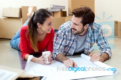 Young Couple Looking At The Blueprints Of Their New Home Stock Photo