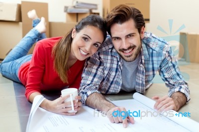 Young Couple Looking At The Blueprints Of Their New Home Stock Photo