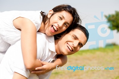 Young Couple Piggy Backing Stock Photo