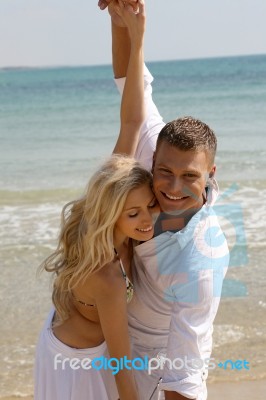 Young Couple Playing At Beach Stock Photo