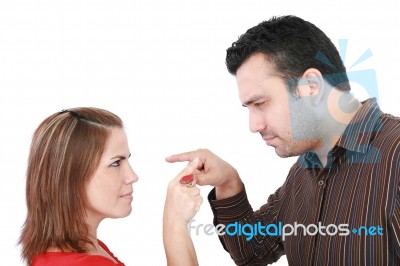 Young Couple Pointing At Each Other Against A White Background Stock Photo