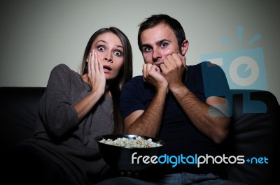 Young Couple Watching Scary Movie On Tv Stock Photo