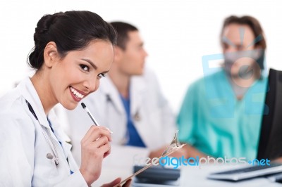 Young Doctor Smiling With Pen Stock Photo