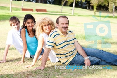 Young Family Relaxing In Park Stock Photo