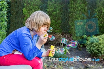 Young Girl Blowing Bubbles From Soapy Water Stock Photo