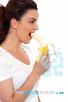 Young Girl Eating Banana Stock Photo