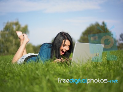 Young Girl Using Laptop In Park Stock Photo