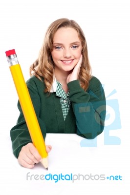 Young Girl Using Over Sized Pencil Stock Photo