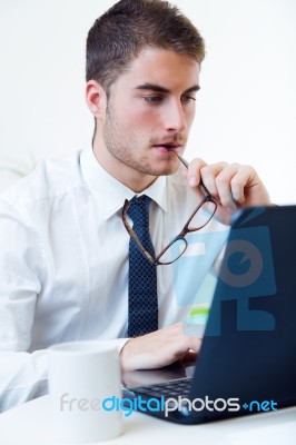 Young Handsome Man Working In His Office With Laptop Stock Photo